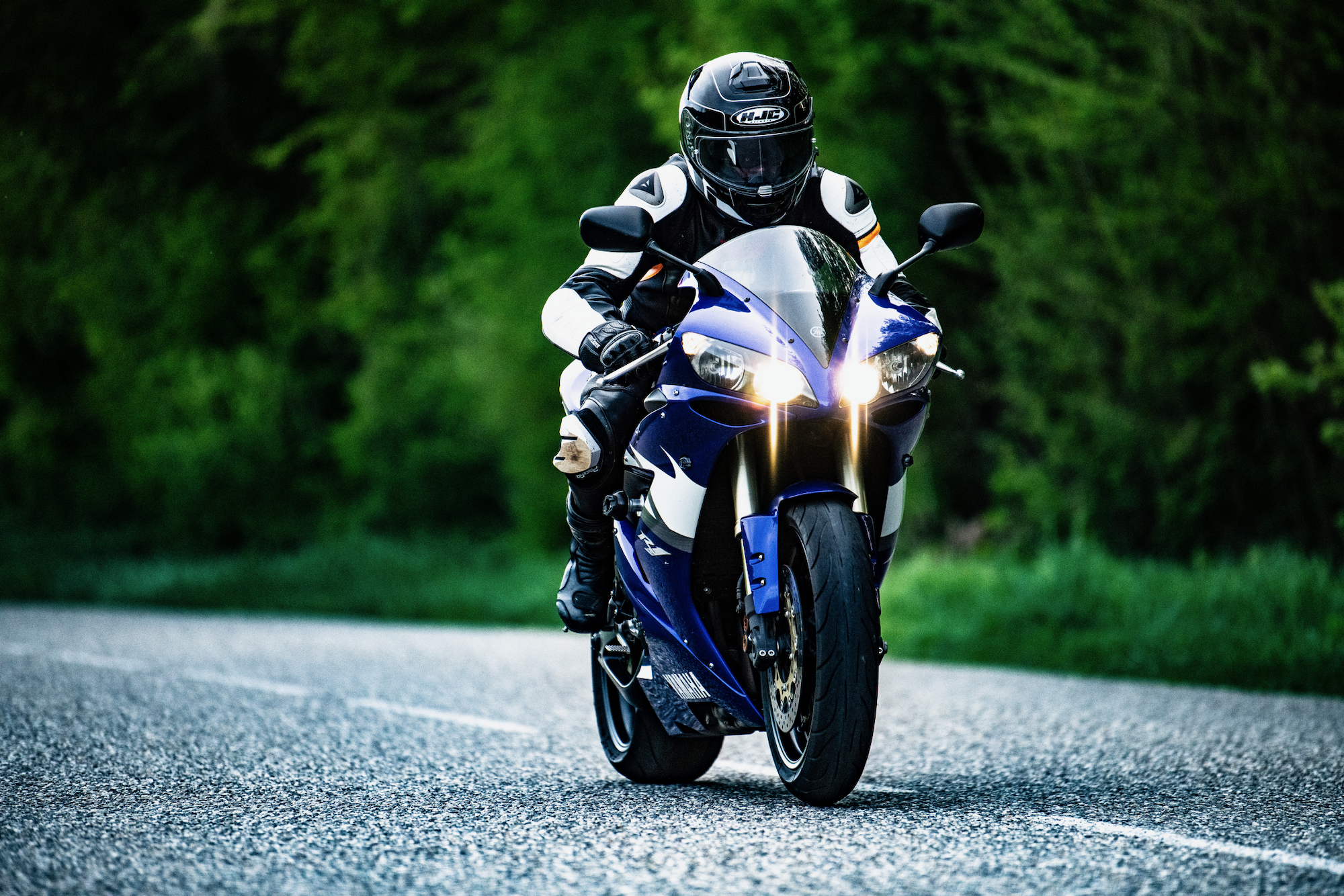 Blaues Motorrad auf einer Waldstraße